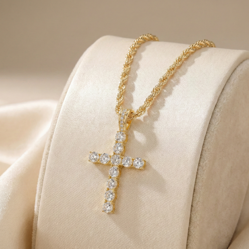 Gold cross necklace with diamonds on a beige fabric background